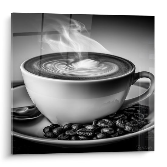 Tasse blanche fumante posée sur grains anthracite, latte art en cœur, tableau café noir et blanc