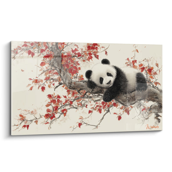 Panda noir et blanc allongé sur une branche parmi des feuilles rouges et crème